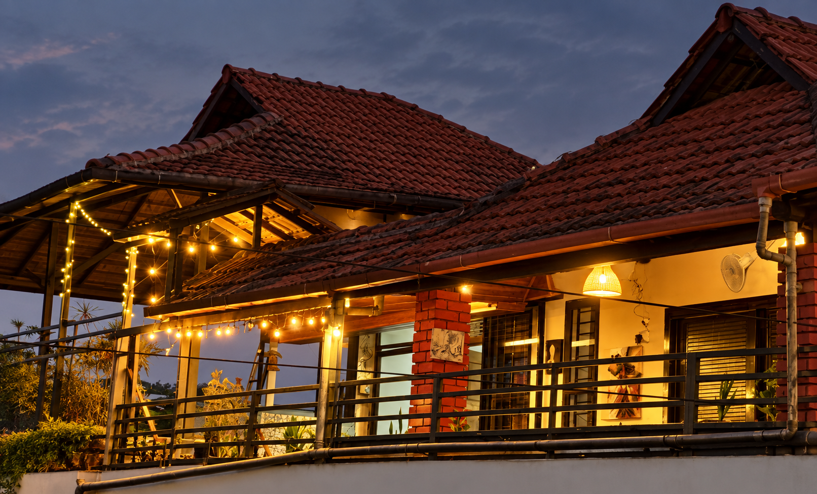 Warmly lit terrace of North Breeze at dusk with string lights